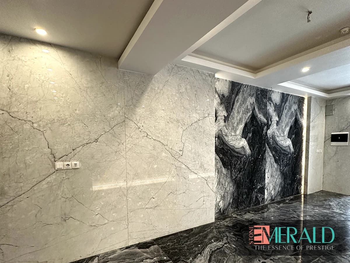 دیوار سنگ روشن رگه‌دار کنار پنل سنگ تیره و نور مخفی